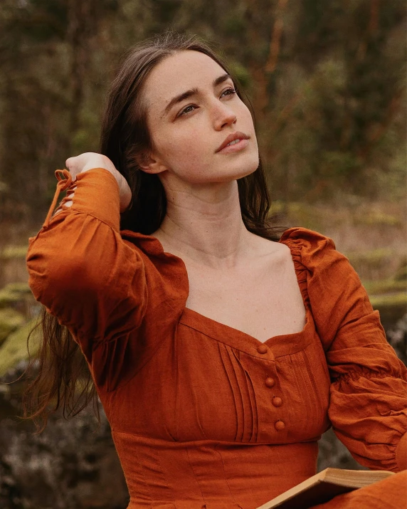 a beautiful young woman sitting down and posing