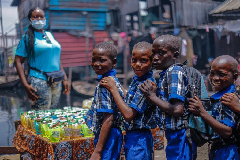 three boys in blue with faces painted standing next to a small table