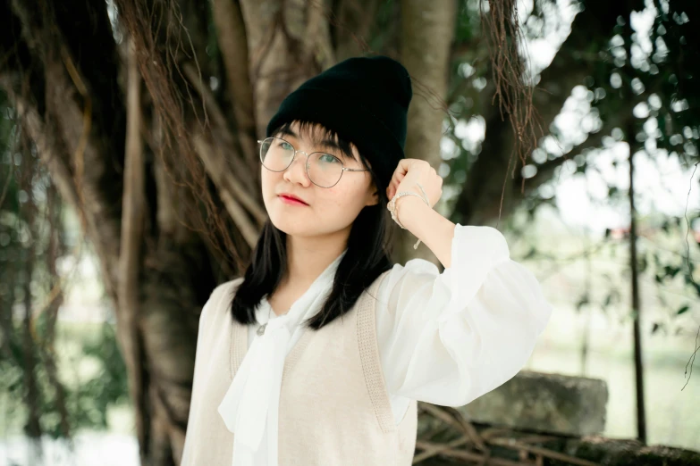 a woman with glasses and hat is posing for the camera