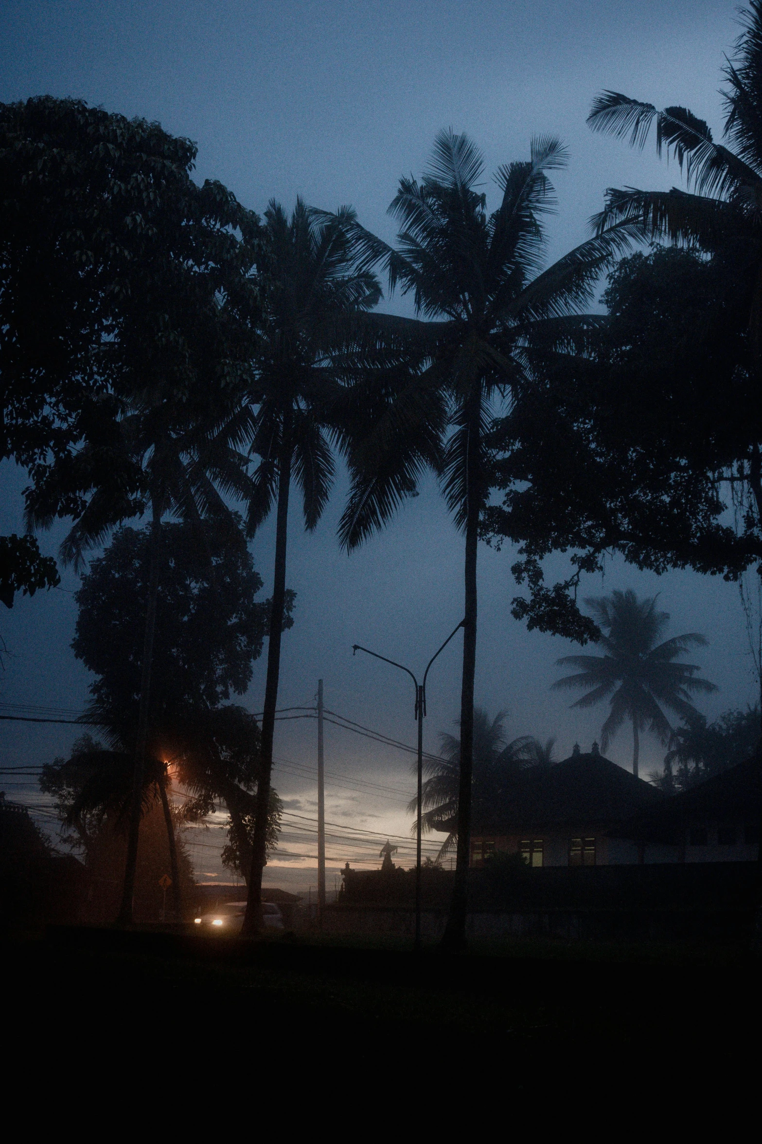 a couple of people are standing in the rain by a light