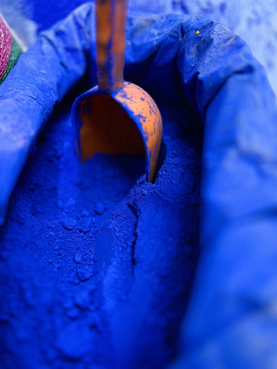 an orange handled pipe is positioned in a blue pot