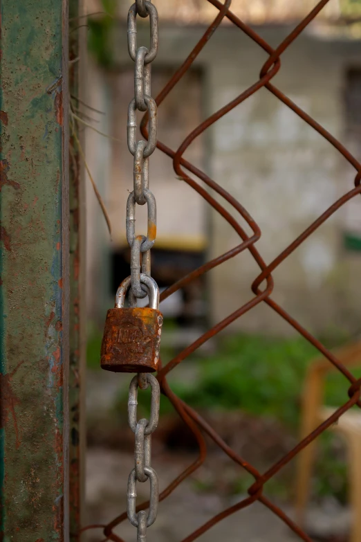 a padlock is secured to a chain on a fence