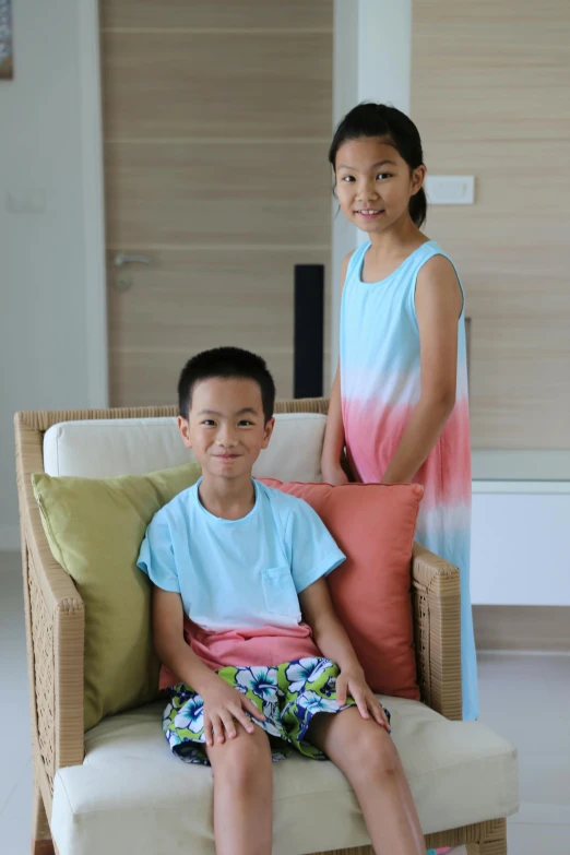 two s in blue, pink and green clothing posing for the camera