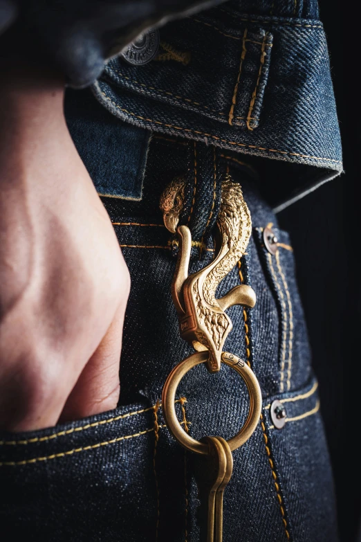 a close up of a person with jeans pockets, both with an embroidered snake key