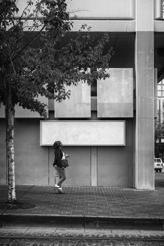 a man skateboarding past a building with a lot of windows