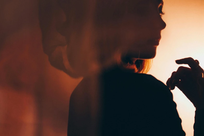 a woman in a shadow next to a light