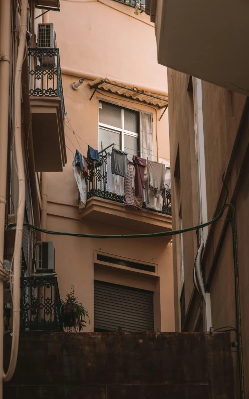 some clothing is on a line outside an apartment