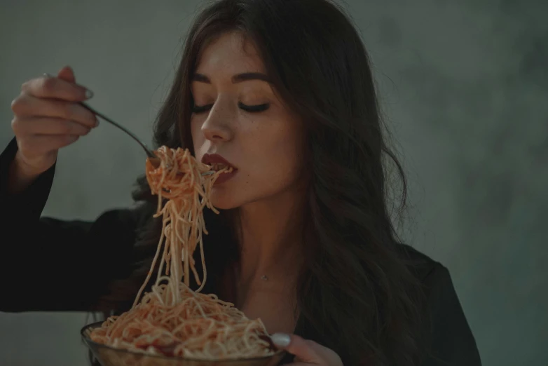 woman eating a very long pile of noodles from a bowl