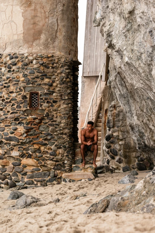 man sits on steps next to a building