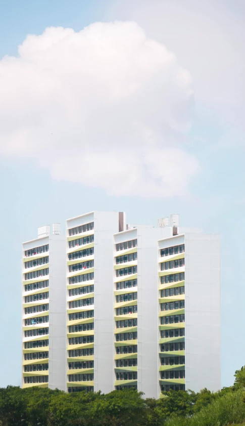 two buildings near trees under a blue cloudy sky