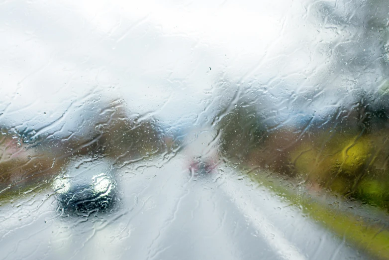 a wet windshield shows a street and buildings