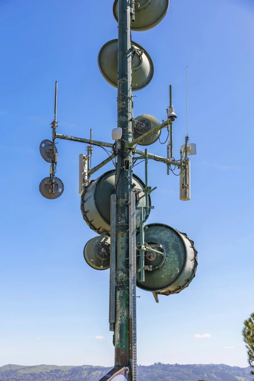 a phone tower next to some wires with cellular towers on top