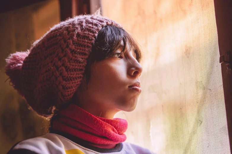 a close up of a young person wearing a hat and scarf