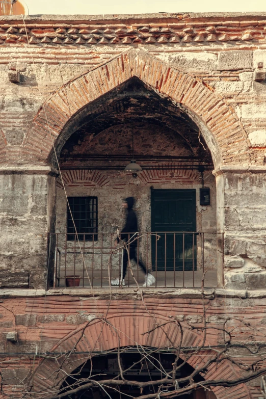 a brick building with an open door, surrounded by vines