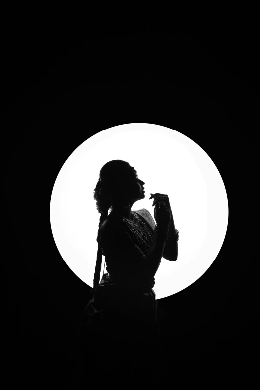 a person standing in front of a large circular light