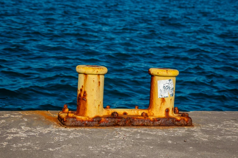 some old and rusty thing sitting by the ocean