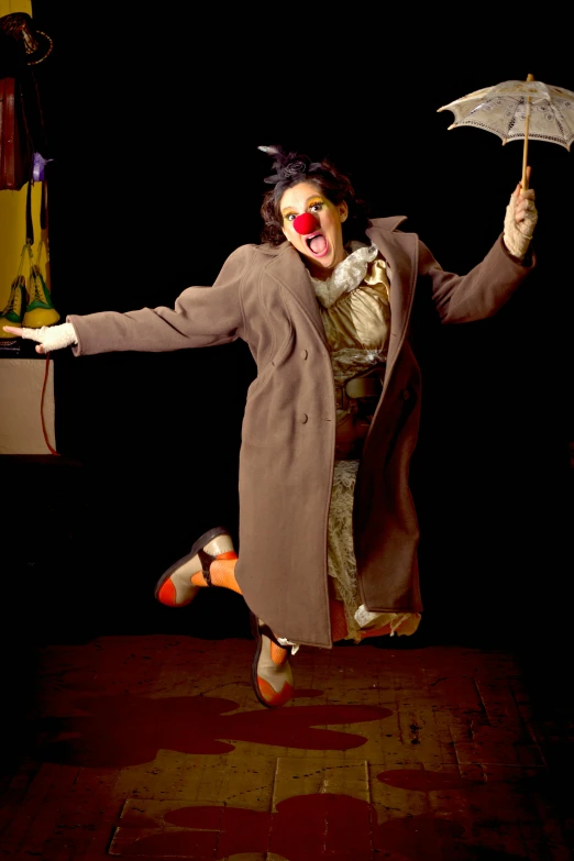 a creepy clown with red nose and costume jumping up