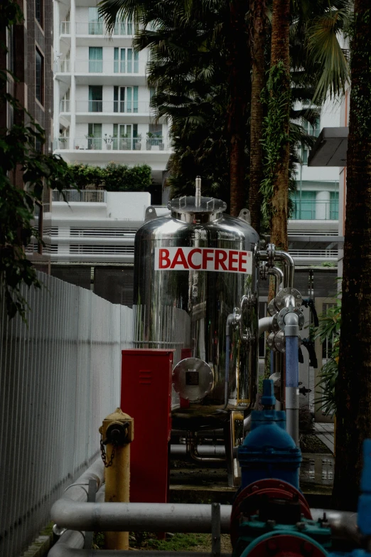 several pipes with a steel tank sitting near a building