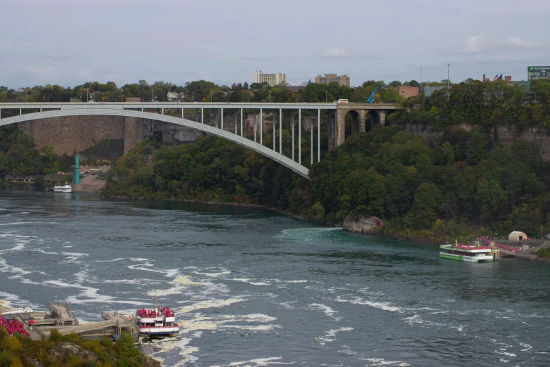 a bridge over a river with boats traveling under it