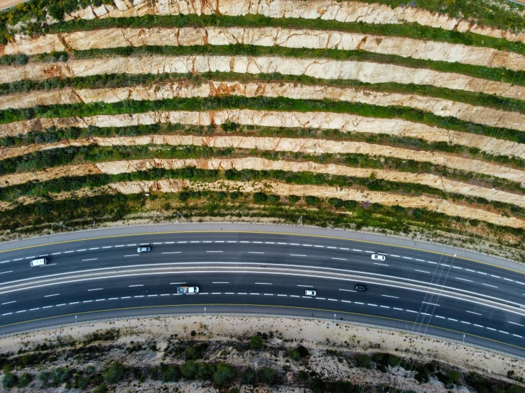 overhead view of a paved road running beside a cliff