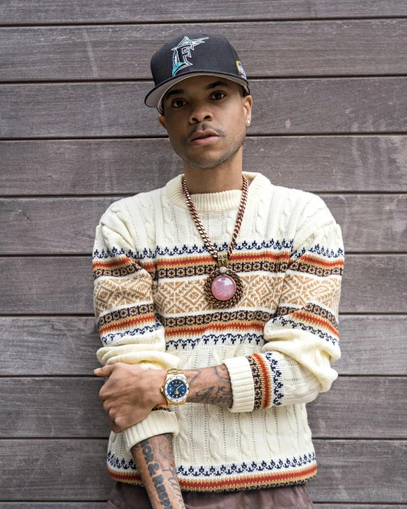 a young man posing with his arms crossed and an old hat