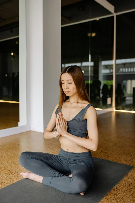 a woman is sitting on the floor in yoga attire