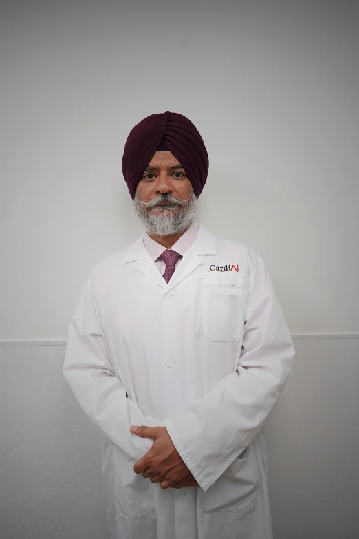 a man in a turban standing in front of a white wall