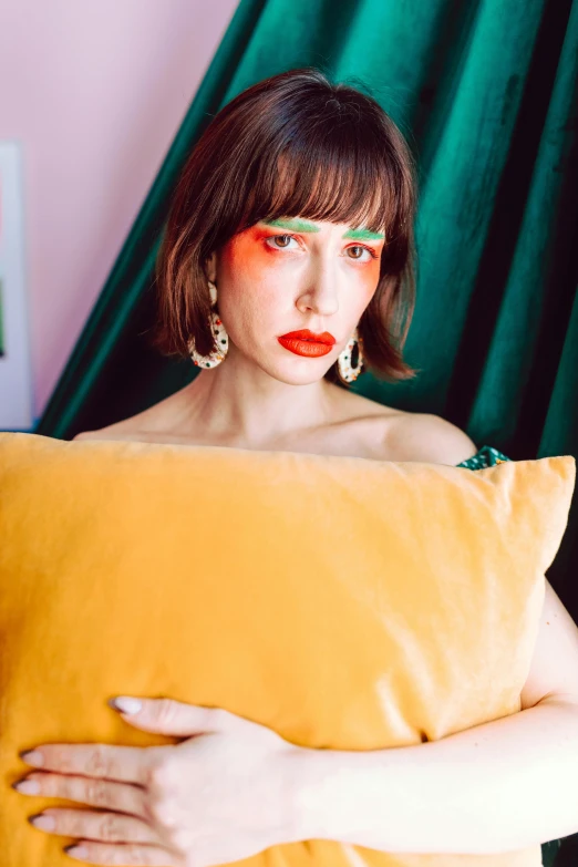 a woman with a red lipstick holds a yellow pillow