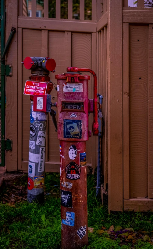 a red fire hydrant covered in various stickers and writing