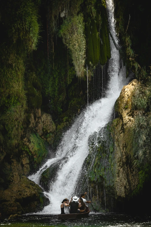 a person riding a small boat near a waterfall