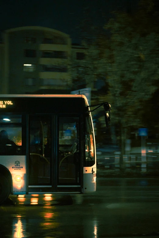 a city bus sits parked along the side of a street at night