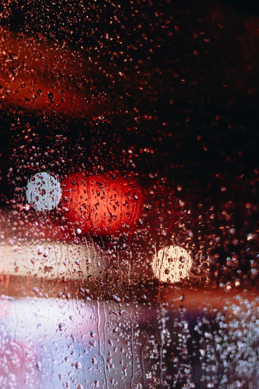a car light from inside the rain sits at red lights
