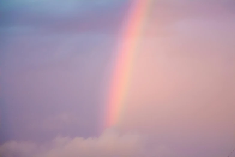 a rainbow shines brightly through the clouds