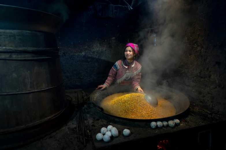 a woman stirring food on a pan with smoke coming from it