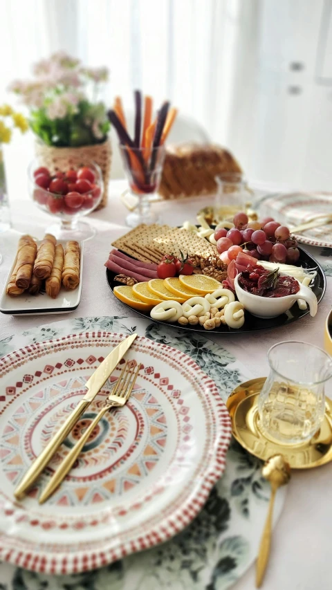 the table has plates, trays, and silverware on it