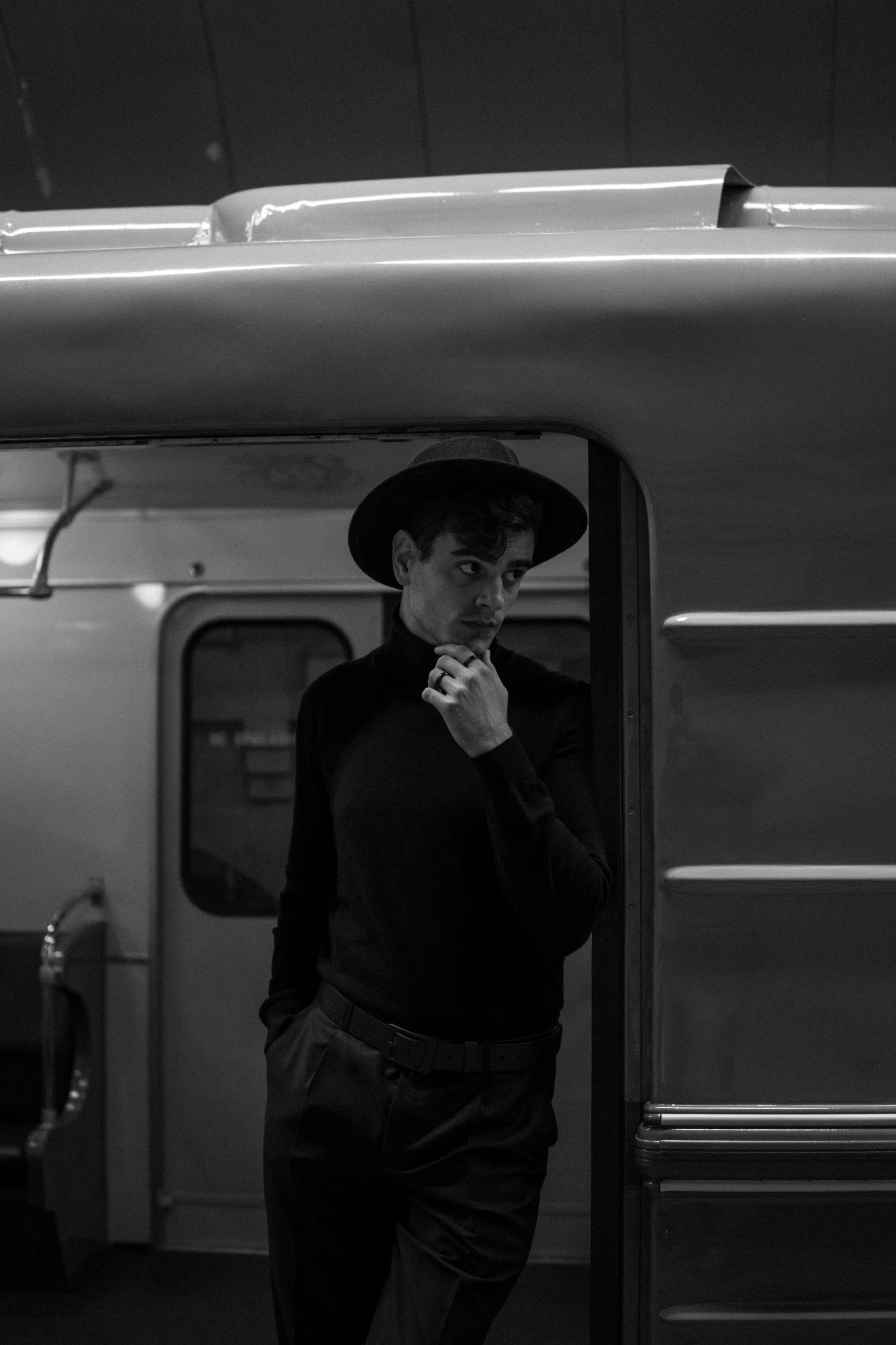 a man standing next to a train while smoking a cigarette