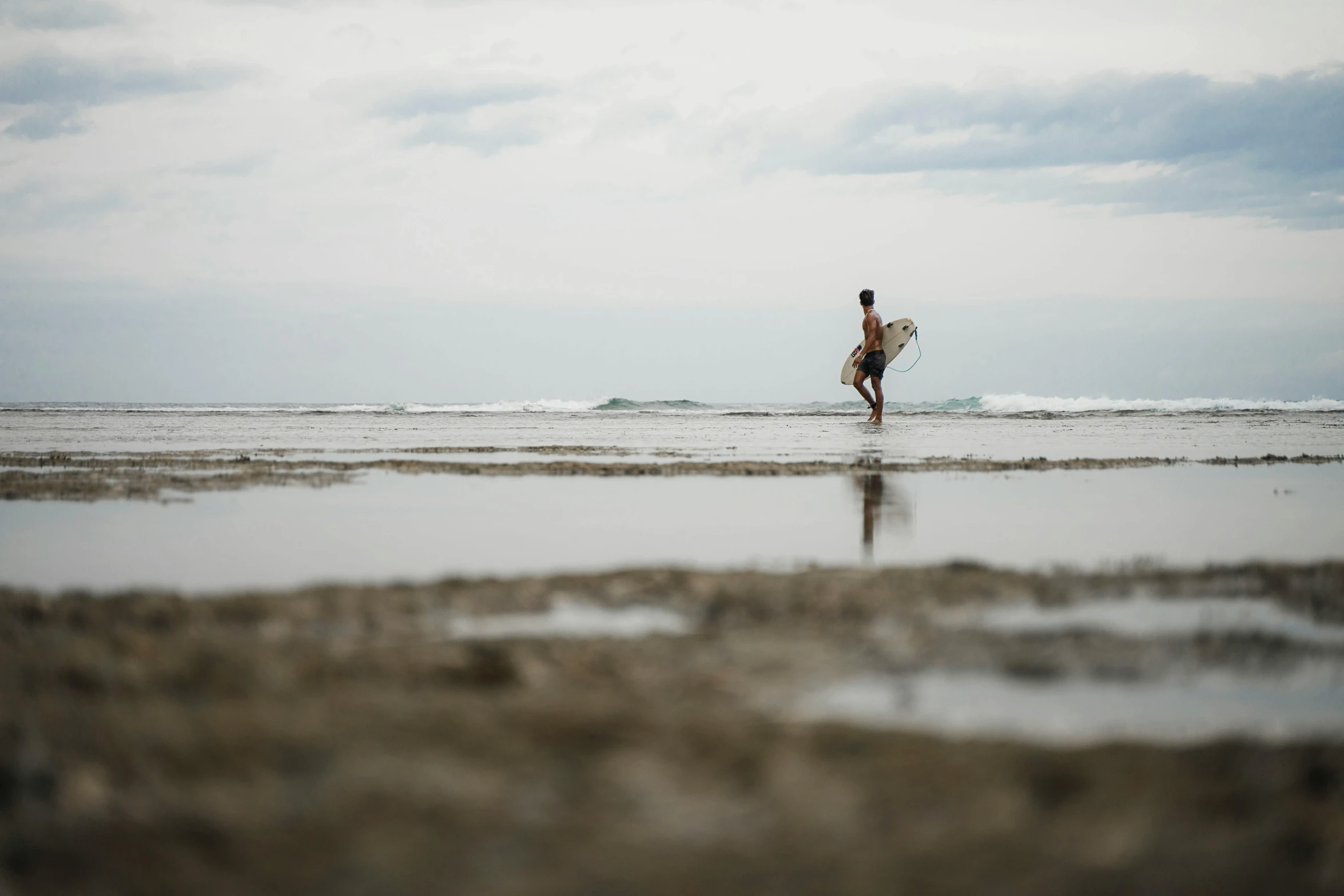 a person with a surfboard is walking through the water