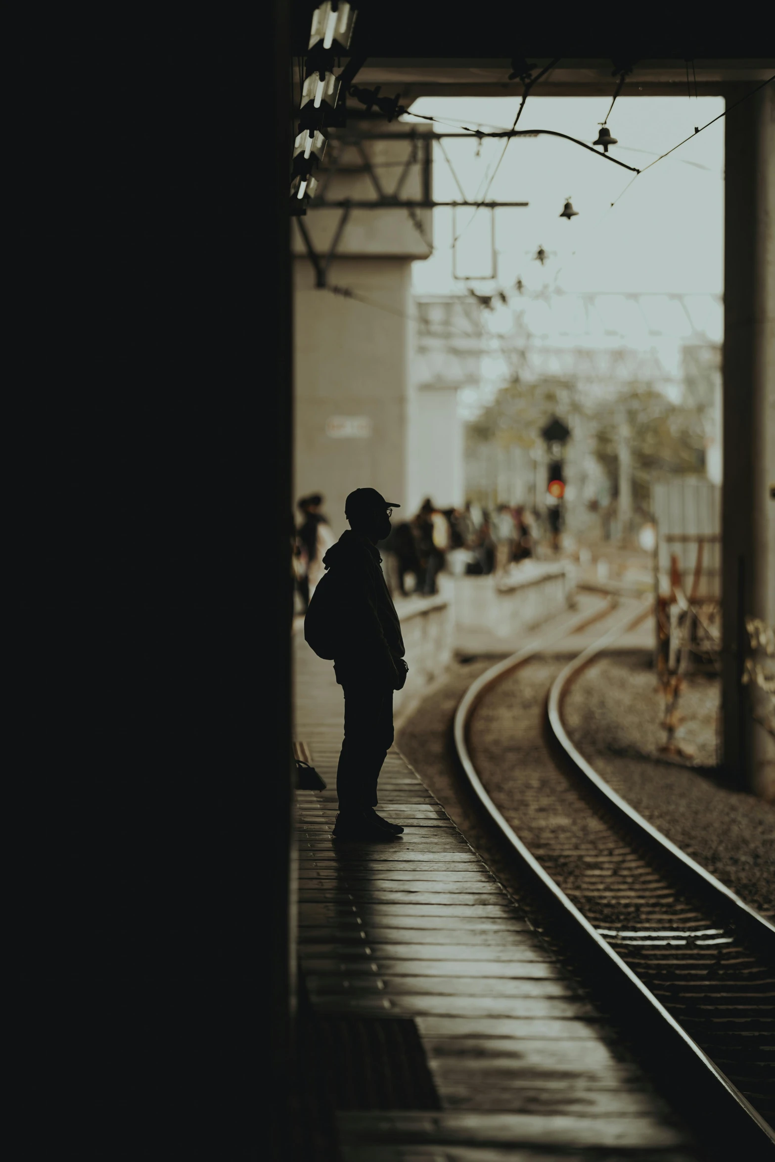 a man standing in the train station, waiting for his next ride
