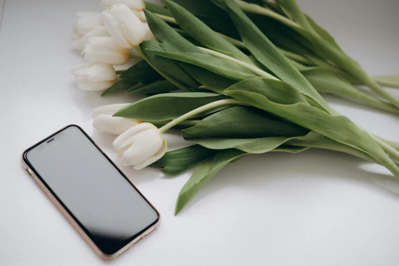 a bouquet of flowers next to an iphone