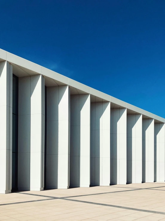 a sidewalk and some tall white columns