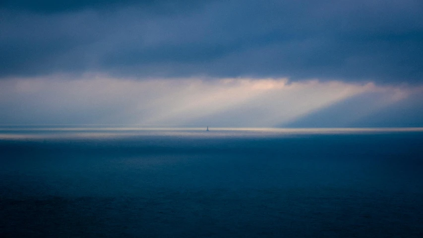 a view from the top of the ocean on a dark cloudy day
