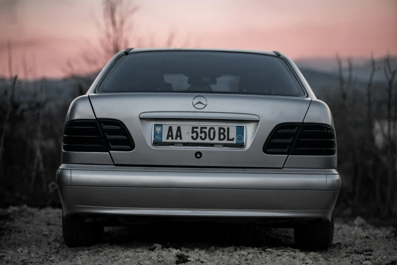 a silver car parked in a dusty parking lot