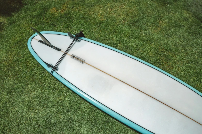 a small surfboard sits alone on the ground