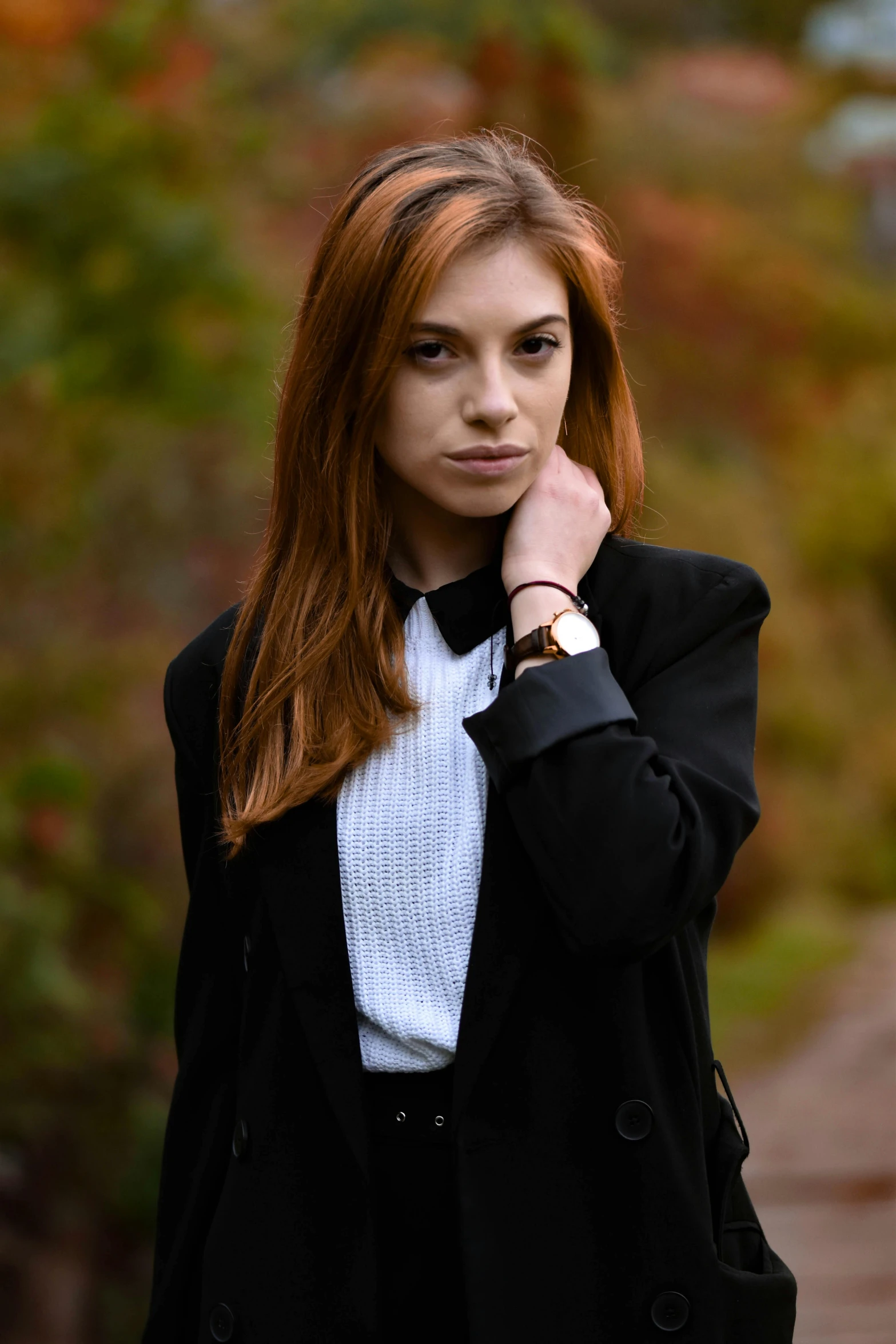 a woman posing in front of the camera with red hair