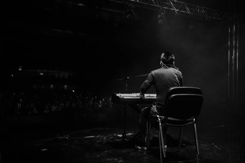 a man playing piano in a darkened room