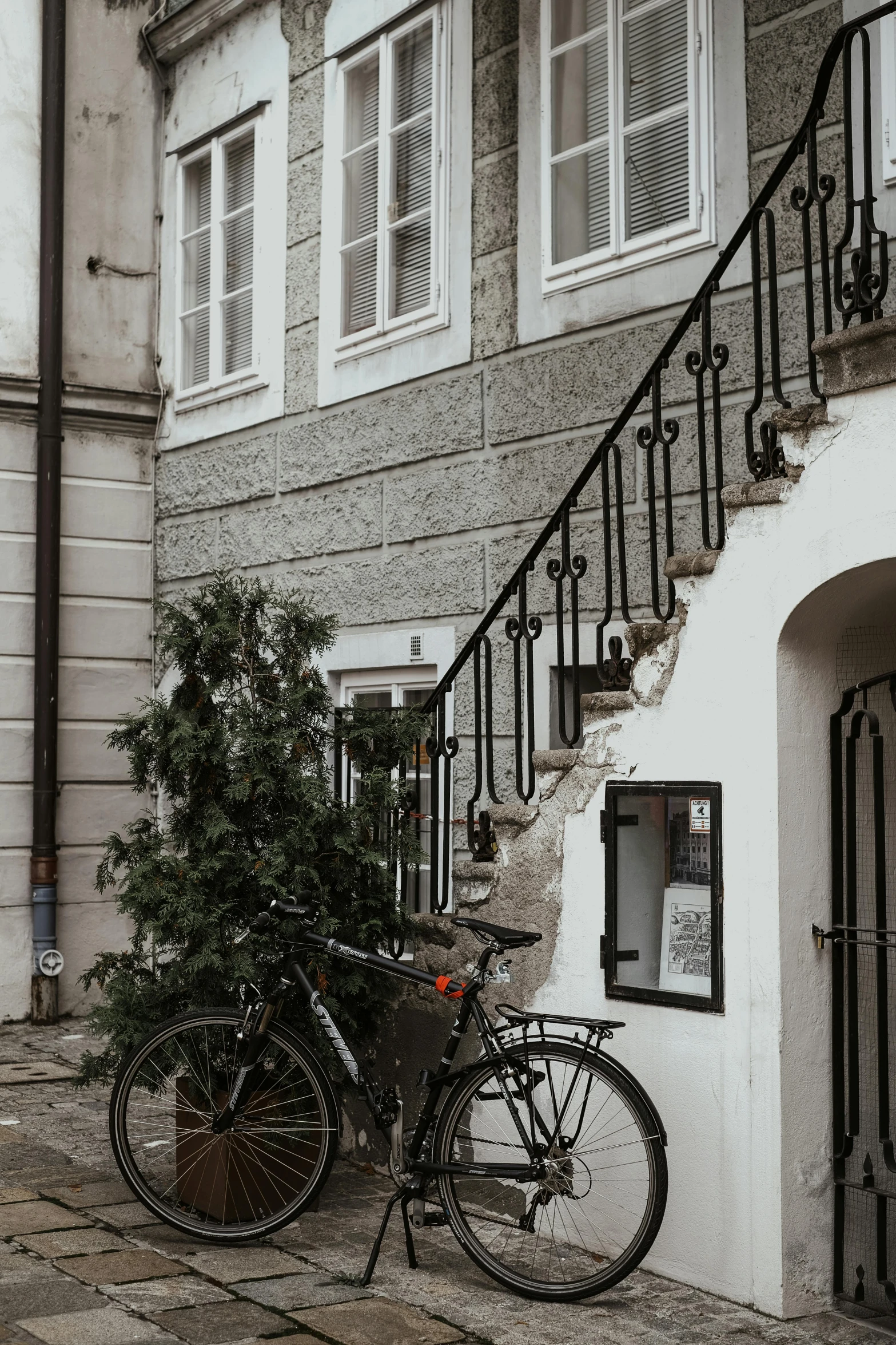 a black bicycle parked in front of a white building