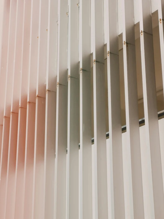 an orange and pink building's facade with vertical stripes of paint