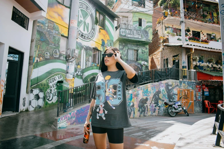 woman in black shirt standing by painted wall with cell phone