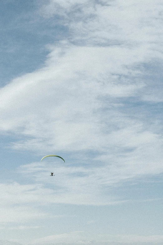 two people standing on a beach flying a kite