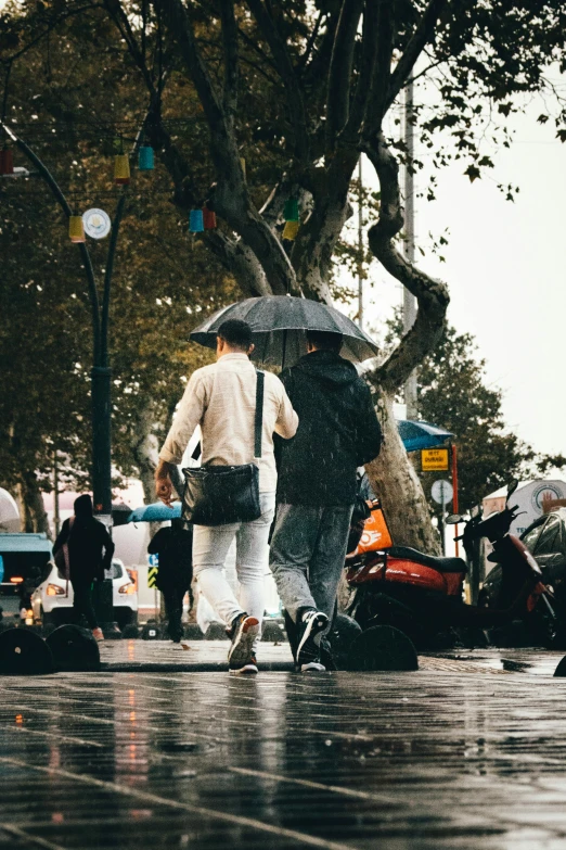 there are people walking on the street with umbrellas